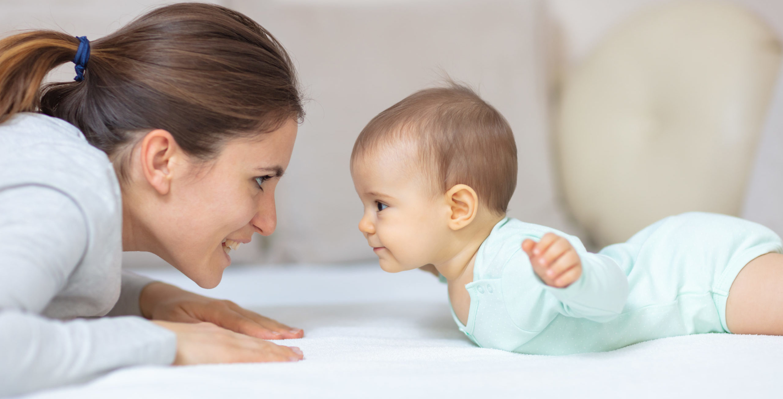Mother and baby playing on the bed